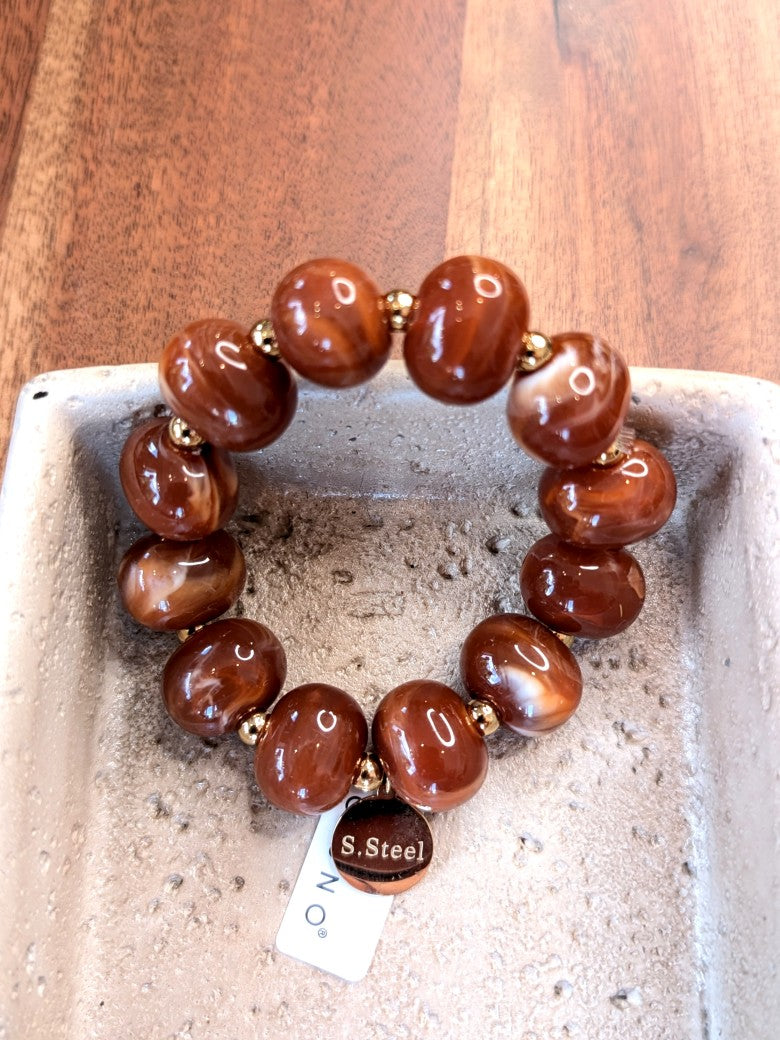 Elegantes elastisches Armband mit großen Acryl-Ovalen in Perlmutt Braun Cognac. Das hochwertige Design verbindet moderne Ästhetik mit komfortablem Tragekomfort!