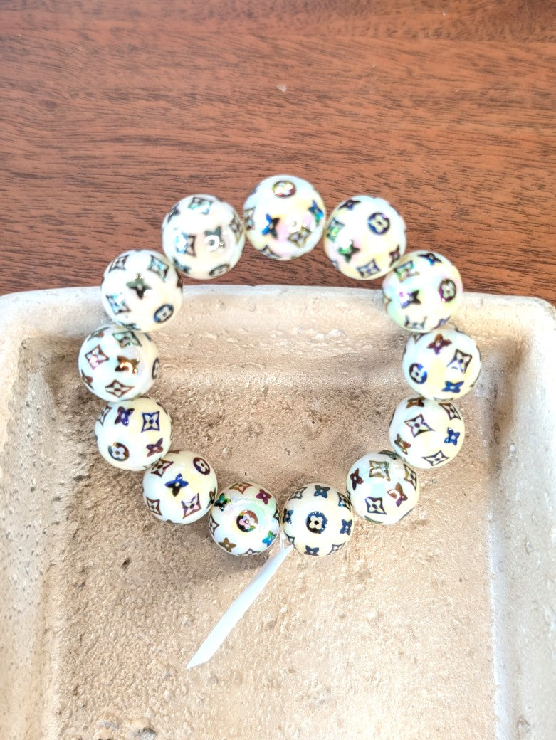 Zeigen Sie Persönlichkeit mit unserem großartigen elastischem Armband mit mega schönen Perlen aus Acryl und Kupfer im Louis Vuitton Stil Créme Braun Rainbow!