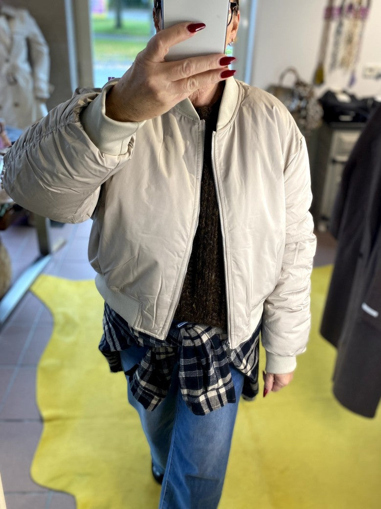 Die Bomberjacke aus hochwertigem Nylon in Beige Hellgrau verbindet urbanen Stil mit angenehmem Tragekomfort - perfekt und stilvoll für die kalte Jahreszeit!