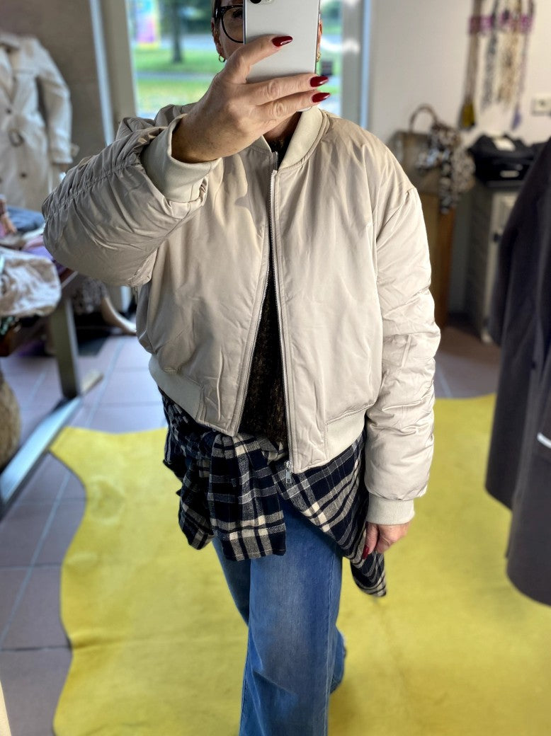Die Bomberjacke aus hochwertigem Nylon in Beige Hellgrau verbindet urbanen Stil mit angenehmem Tragekomfort - perfekt und stilvoll für die kalte Jahreszeit!