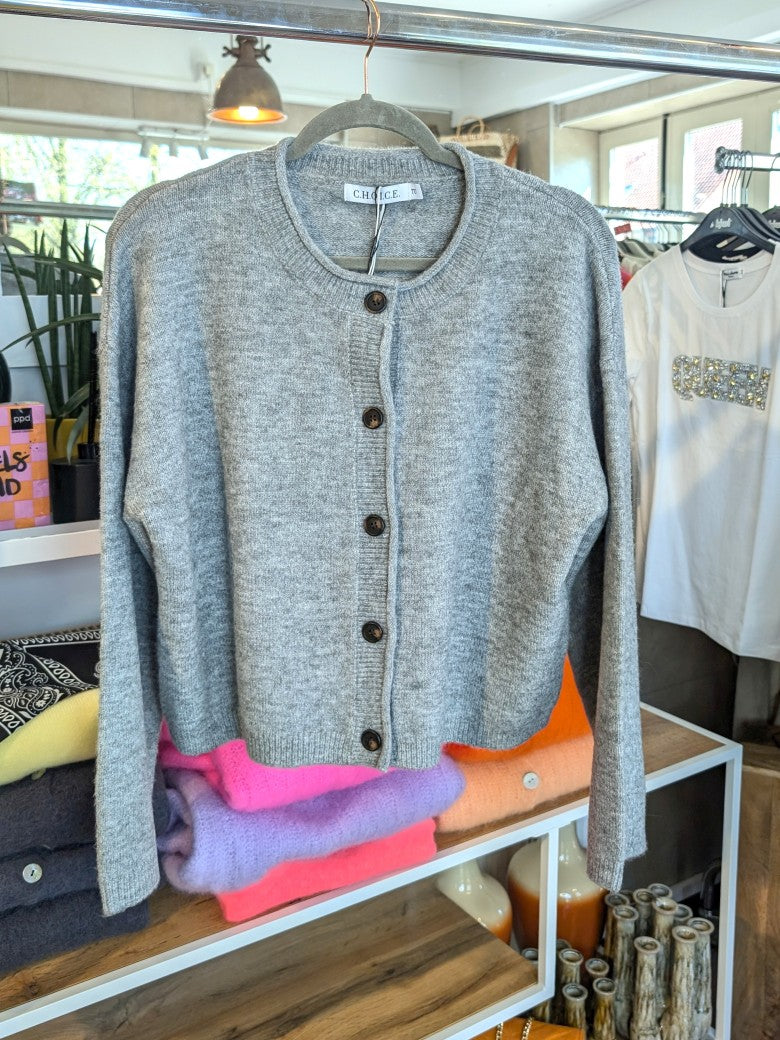 Die gemütliche Strickjacke aus einer hochwertigen Viskose Mischung in elegantem Hellgrau mit braunen Knöpfen verbindet stilvolles Design und Tragekomfort!