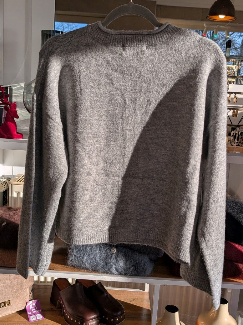 Die gemütliche Strickjacke aus einer hochwertigen Viskose Mischung in elegantem Hellgrau mit braunen Knöpfen verbindet stilvolles Design und Tragekomfort!