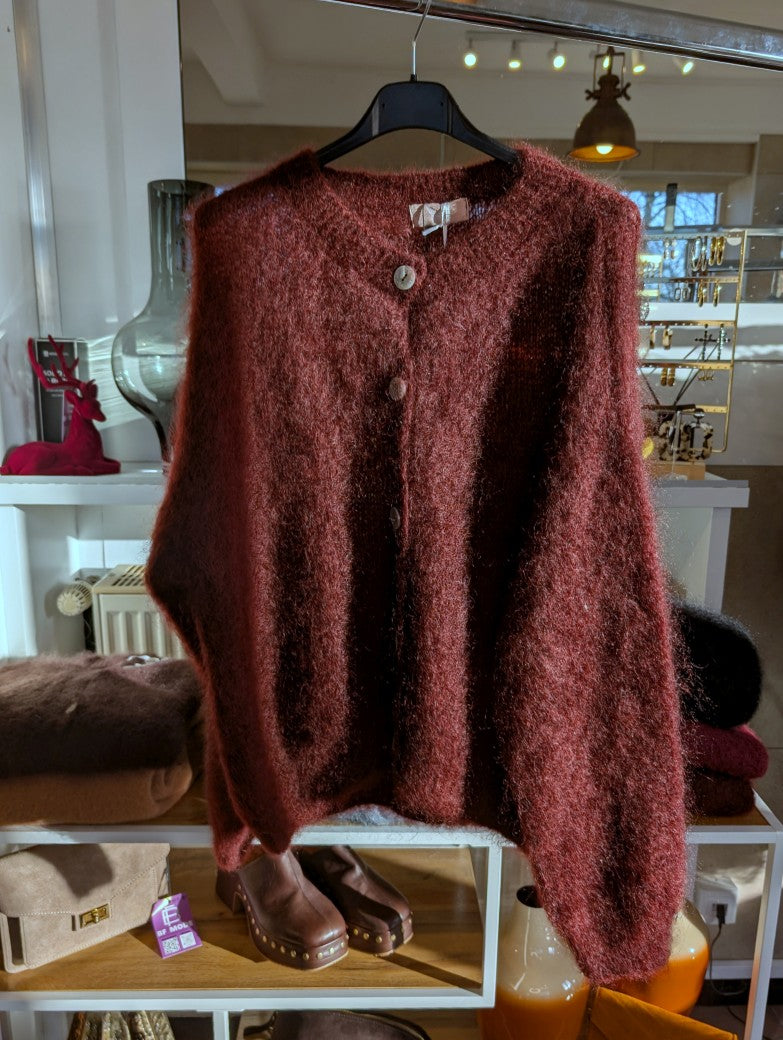Fühle dich behaglich und stilvoll mit unserer Cardigan Strickjacke aus 80% Mohair in Weinrot und Braunstich mit Perlmuttknöpfen. Perfekt für alle Gelegenheiten!