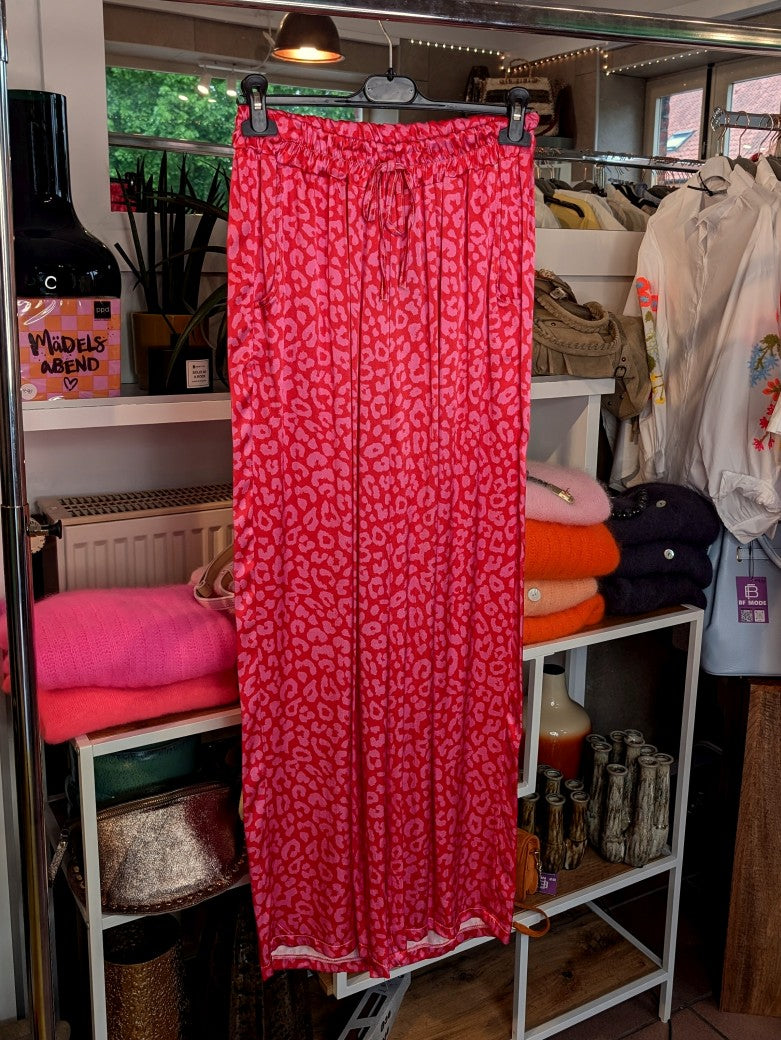 Stilvoll und sinnlich! Die rote Hose aus Satin Viskose mit Leo Muster in Pink ist ein echter Hingucker. Entdecke jetzt einen neuen, aufregenden Stil!