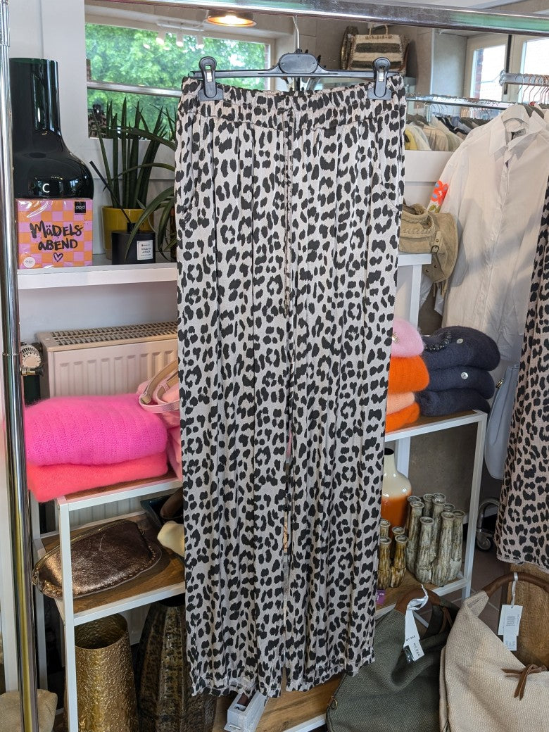 Steigere deinen Style mit unserer Hose aus Satin Viskose! Das Leo Muster in Hellgrau Silber und Schwarz verleiht deinem Outfit einen wilden Look!
