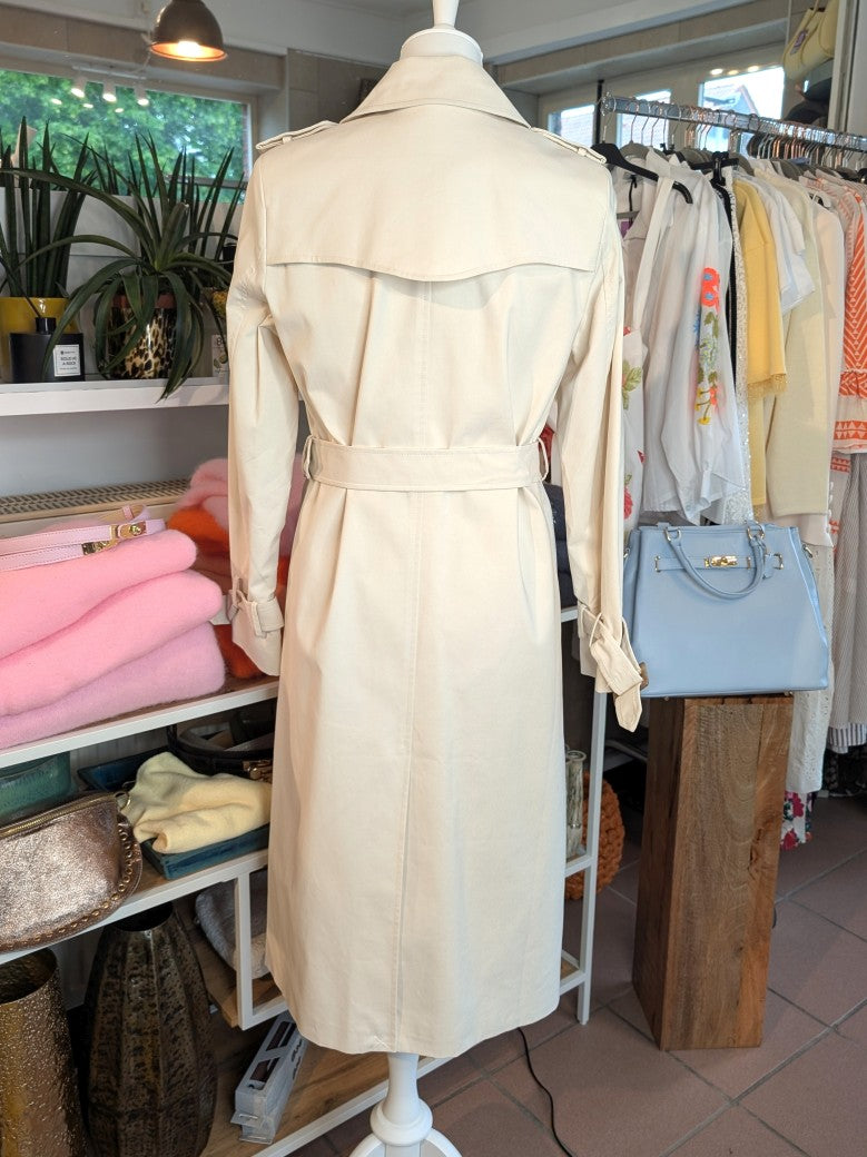 Der lange doppelreihige Trenchcoat Mantel in Creme aus Baumwolle von ATTENTIF kombiniert stilvollen Schnitt und zeitlose Eleganz für anspruchsvolle Damenmode.
