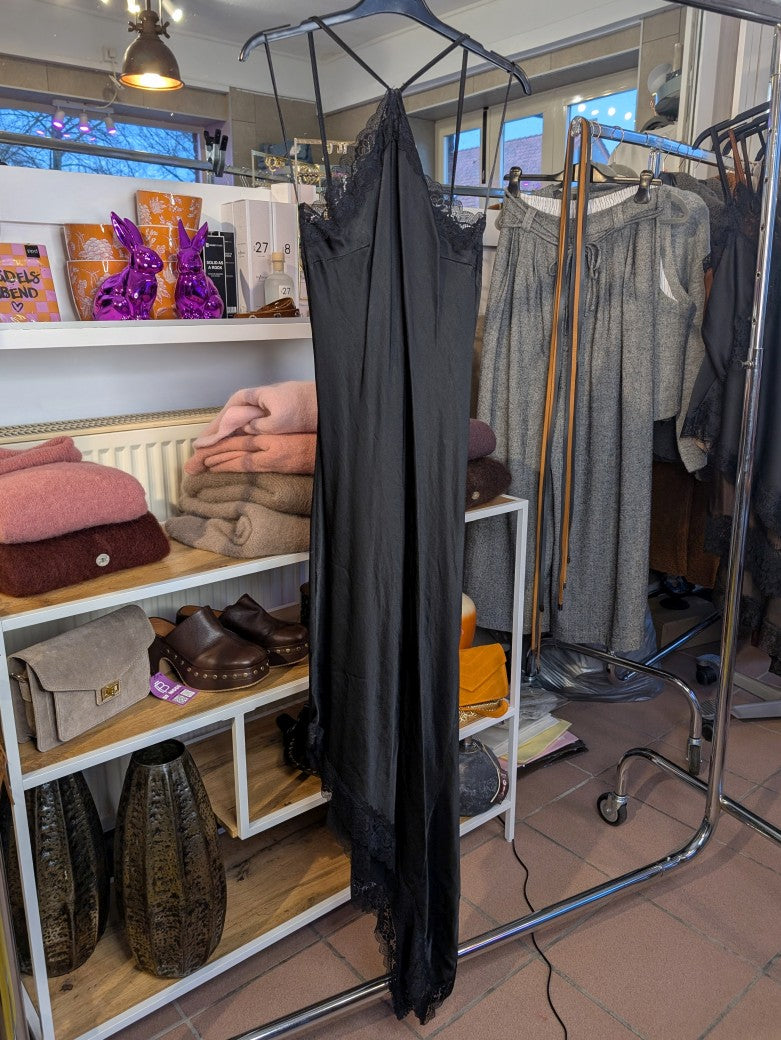 Das asymmetrische Kleid aus seidenmattem Viskose Satin in Schwarz mit schwarzer Spitze wirkt ideal über Pants und Jeans - femininer absoluter Hingucker!