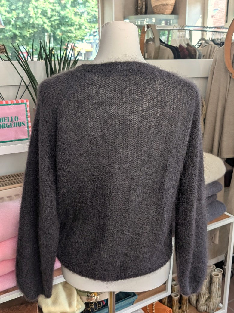 Der weiche Mohair-Pullover aus 80% Kid Mohair Anthrazit mit V-Ausschnitt verbindet flauschigen Komfort mit eleganten Knotendesign - perfekt für kühlere Tage!