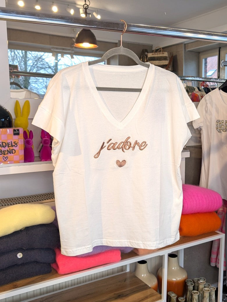 Das stylische T-Shirt J'Adore in Weiß mit Schriftzug in Roségold ist der perfekte Sommer-Look-Hingucker – vom lässigen Stadtbummel bis zum eleganten Abend-Outfit!