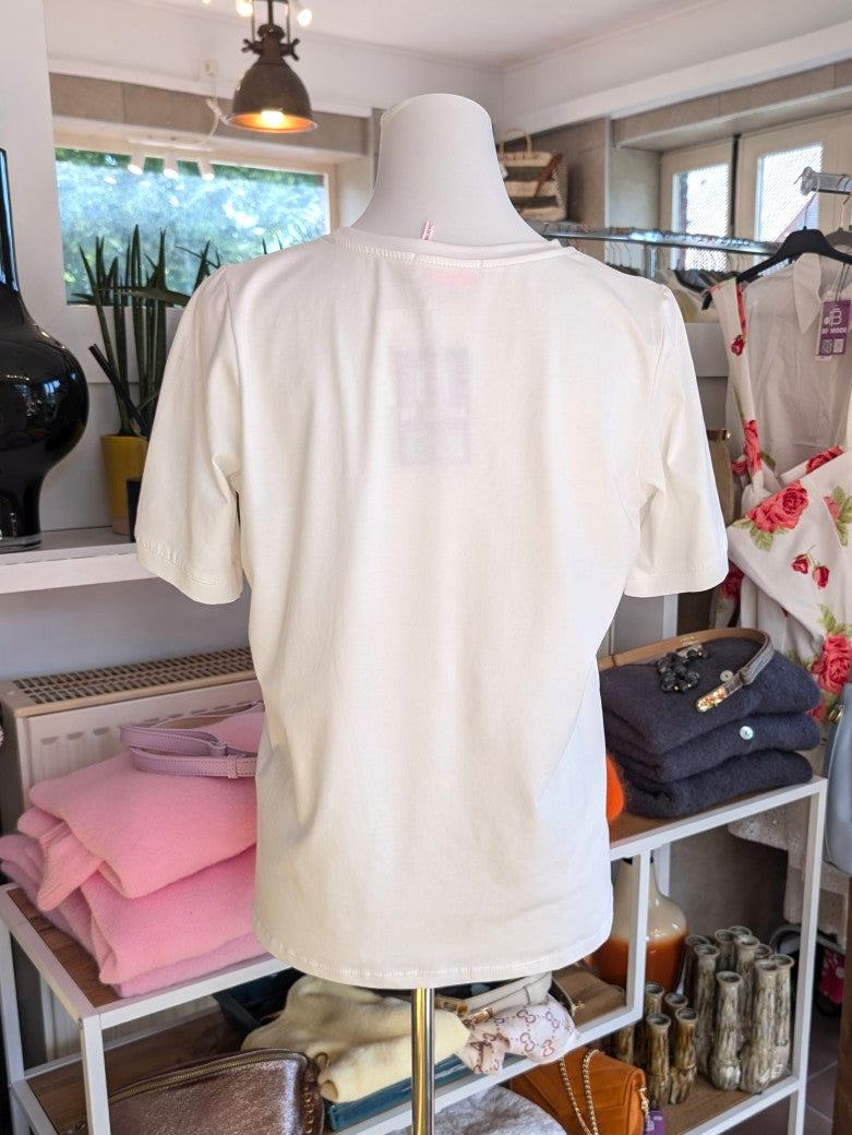 Das T-Shirt in Créme mit leuchtendem Pink aus hochwertiger Baumwolle ist perfekt für Yoga und Alltag - setze ein modisches Statement und fühle dich wohl!