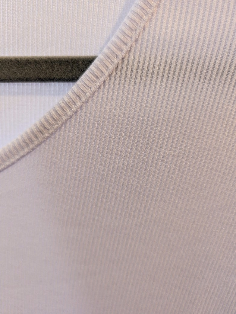 Das elegante gerippte T-Shirt in zartem Rosa besticht durch seinen femininen V-Ausschnitt und die hochwertige Viskose-Qualität - stylebar von lässig bis schick!