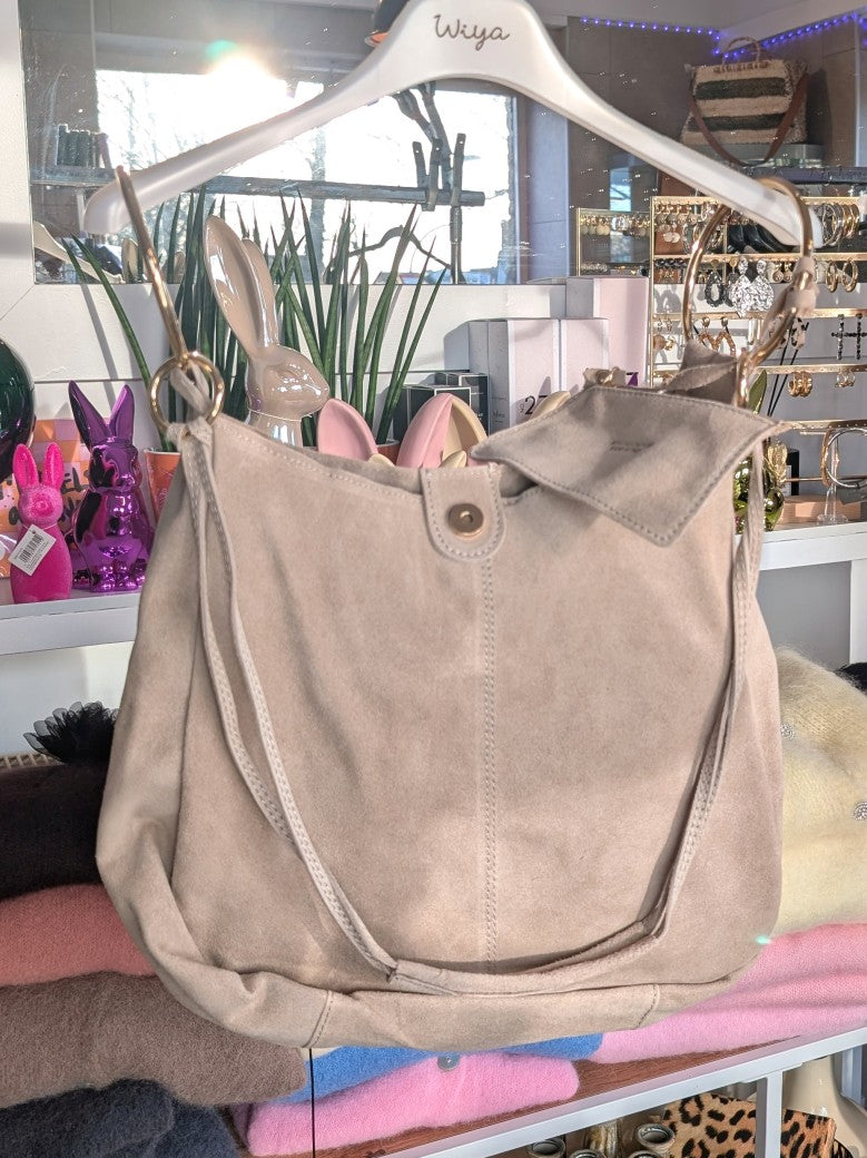 Die elegante Hobo Bag aus hochwertigem Wildleder in elegantem Beige mit herausnehmbarer Innentasche besticht durch goldenen Ösen und italienisches Handwerk.