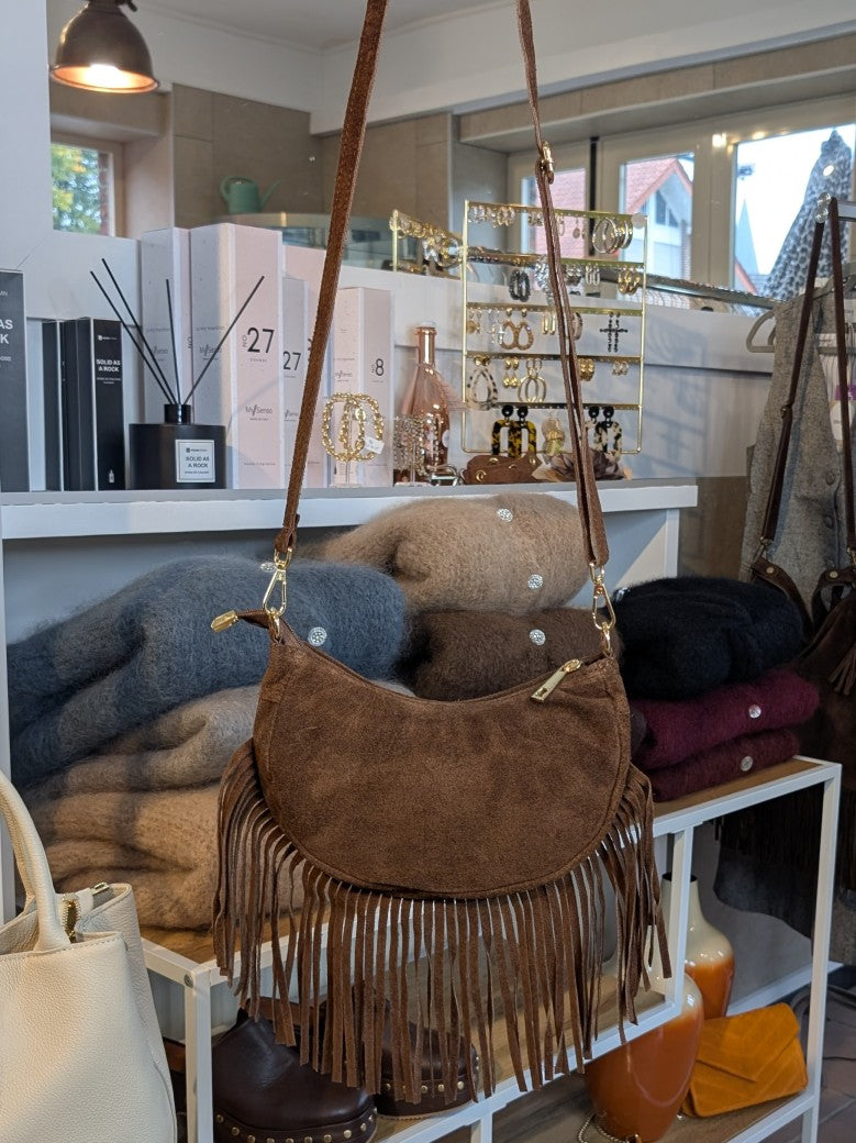 Die Wildledertasche in warmem Braun überzeugt mit Halbmond-Form, Schulterriemen, RV und stilvollen Fransen - verleiht jedem Outfit eine trendige Note!