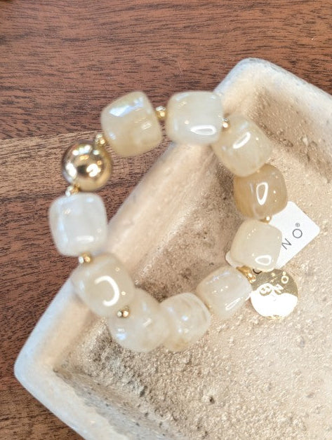 Elegantes elastisches Armband mit großen taupe-milchigen Acrylquadraten. Das hochwertige Design verbindet moderne Ästhetik mit komfortablem Tragekomfort!