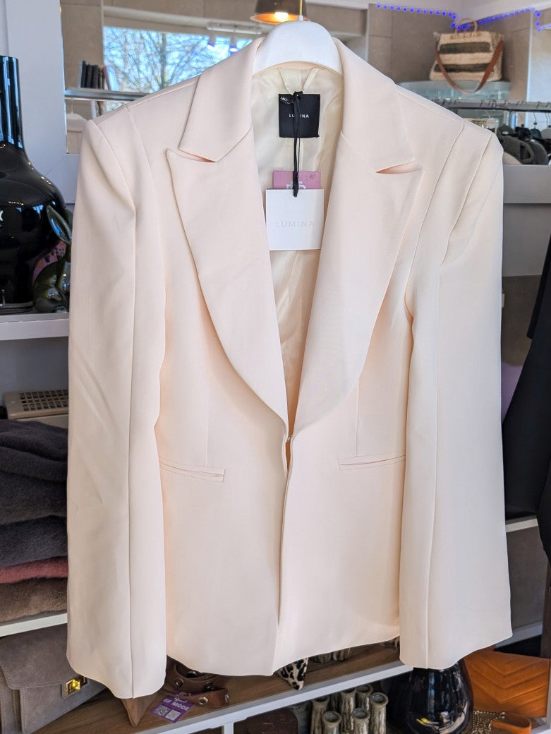 Eleganter Blazer mit markanten Schulterpolstern von Lumina in elegantem Créme. Perfekt für professionelle Anlässe oder stilvolle Alltagskombinationen.