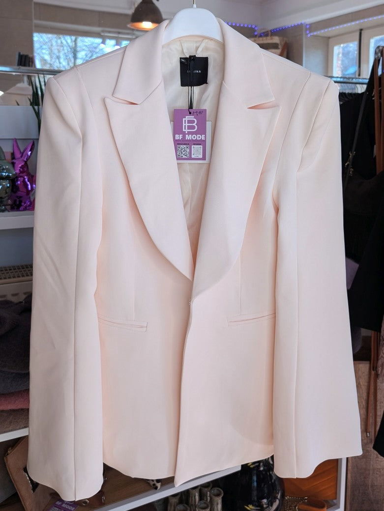 Eleganter Blazer mit markanten Schulterpolstern von Lumina in elegantem Créme. Perfekt für professionelle Anlässe oder stilvolle Alltagskombinationen.