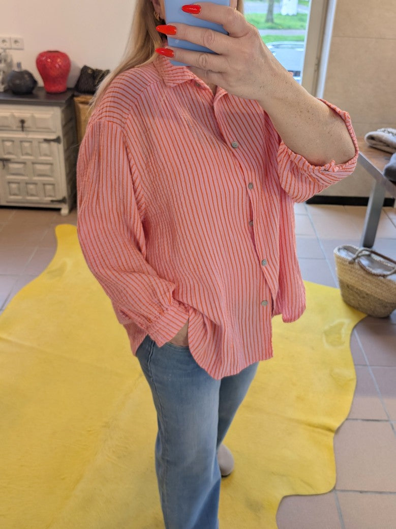 Die elegante gestreifte Bluse aus Mousselin in Rosa Orange mit leichtem luftigen Material ist ein Must-Have für den Kleiderschrank.  Stilvoll für jeden Anlass!