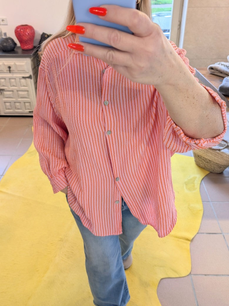 Die elegante gestreifte Bluse aus Mousselin in Rosa Orange mit leichtem luftigen Material ist ein Must-Have für den Kleiderschrank.  Stilvoll für jeden Anlass!