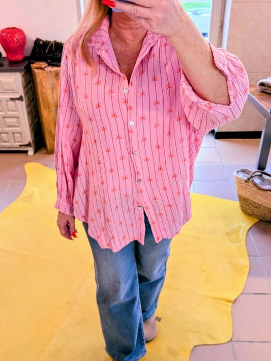 Entdecken Sie unsere wunderschöne Bluse aus Mousselin in einem zarten Rosa Pink und einem ansprechenden Schleifenmuster in Orange. Perfekt für Frühling und Sommer!