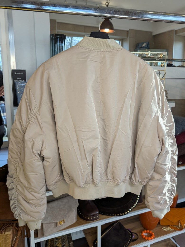 Die Bomberjacke aus hochwertigem Nylon in Beige Hellgrau verbindet urbanen Stil mit angenehmem Tragekomfort - perfekt und stilvoll für die kalte Jahreszeit!