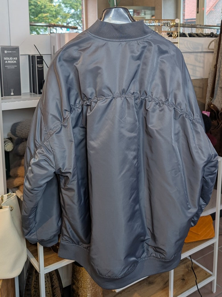 Die oversized Bomberjacke aus hochwertigem Nylon verbindet urbanen Stil mit angenehmem Tragekomfort - mega stylisch in seidigem Blau Grau mit lebendigem Orange!
