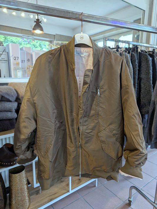 Die oversized Bomberjacke aus hochwertigem Nylon verbindet urbanen Stil mit angenehmem Tragekomfort - mega stylisch in dunklem Taupe mit dezentem Goldschimmer!