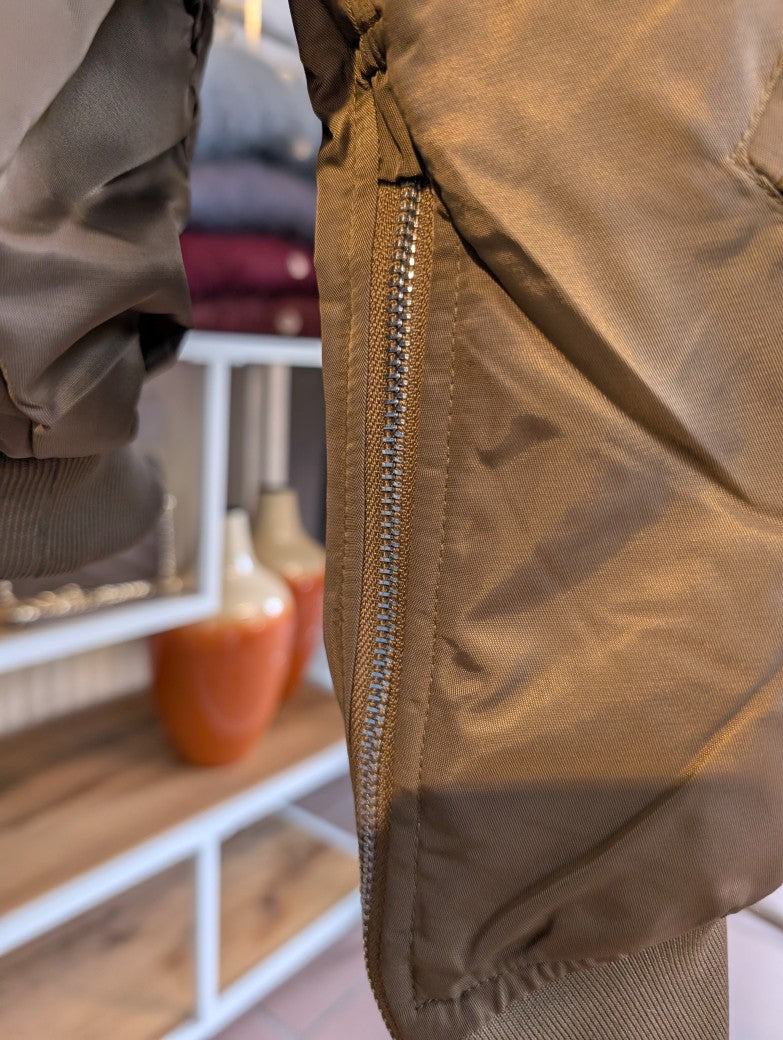 Die oversized Bomberjacke aus hochwertigem Nylon verbindet urbanen Stil mit angenehmem Tragekomfort - mega stylisch in dunklem Taupe mit dezentem Goldschimmer!