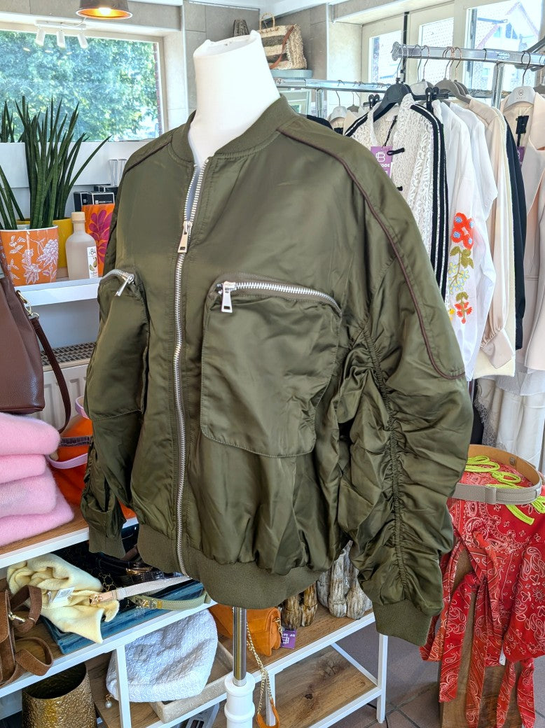 Die MOCHY Oversized Bomberjacke besticht durch lässige Silhouette und hochwertige Materialkomposition aus Viskose und Polyester in trendigem Khaki mit Braun.