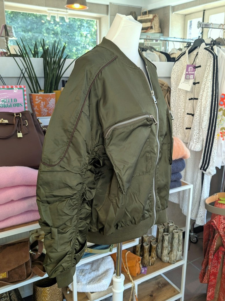 Die MOCHY Oversized Bomberjacke besticht durch lässige Silhouette und hochwertige Materialkomposition aus Viskose und Polyester in trendigem Khaki mit Braun.