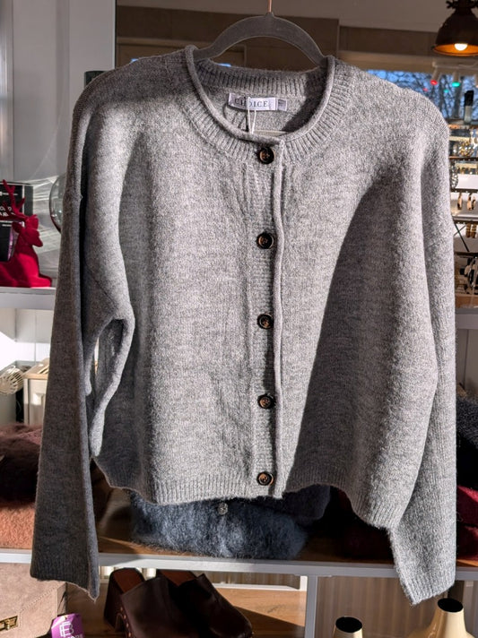 Die gemütliche Strickjacke aus einer hochwertigen Viskose Mischung in elegantem Hellgrau mit braunen Knöpfen verbindet stilvolles Design und Tragekomfort!