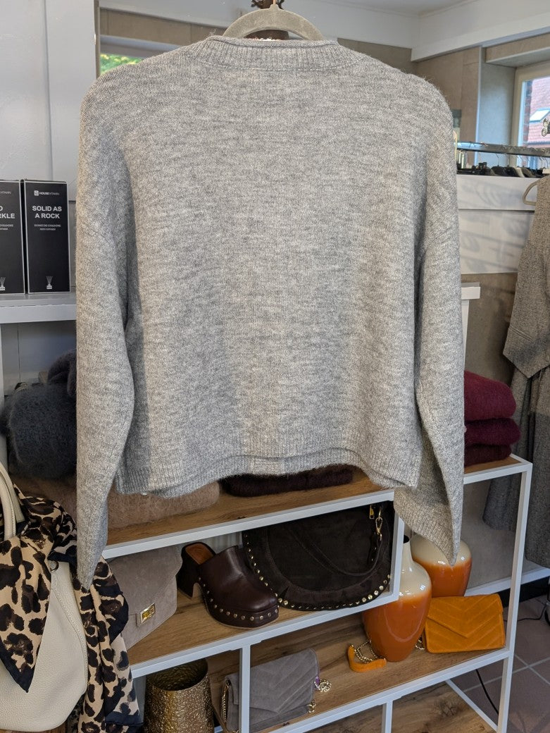 Die gemütliche Strickjacke aus einer hochwertigen Viskose Nylon Mischung in elegantem Hellgrau mit braunen Knöpfen verbindet stilvolles Design und Tragekomfort!