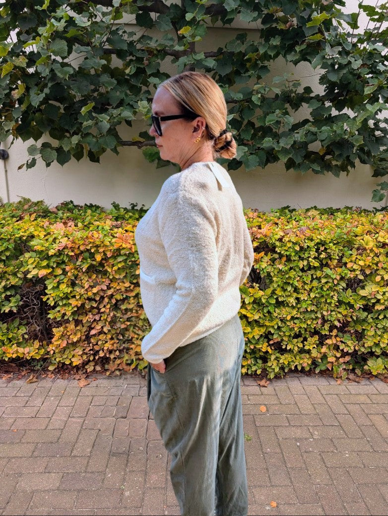 Der elegante creme beige Cardigan im Chanel-Style verbindet zeitlose Eleganz mit modernem Komfort. Die glänzenden Goldknöpfe akzentuieren stilvoll perfekt!