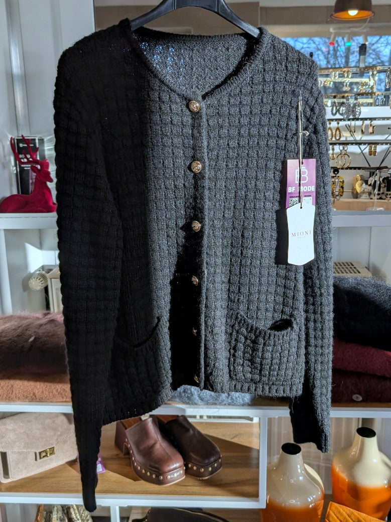 Die schwarze Cardigan-Strickjacke im Chanel-Stil mit ihren markanten Quadrate und edlen Goldknöpfen vereint zeitlose Eleganz mit modernem Komfort!