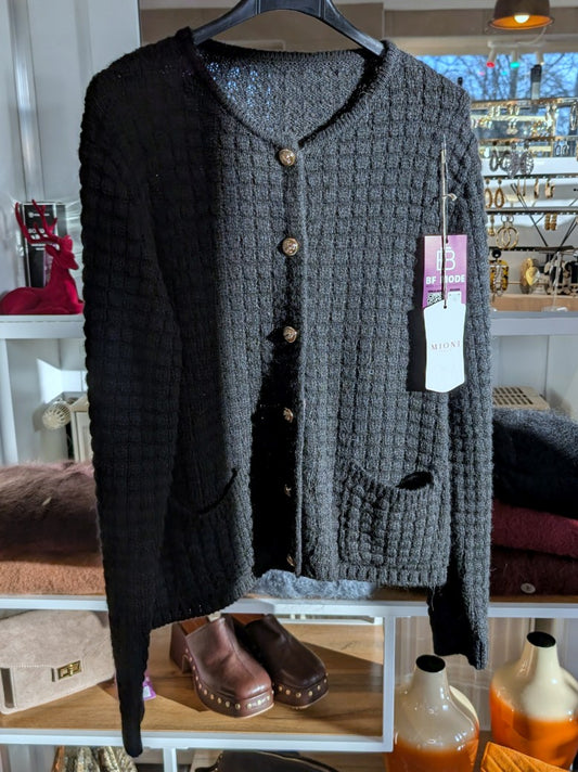 Die schwarze Cardigan-Strickjacke im Chanel-Stil mit ihren markanten Quadrate und edlen Goldknöpfen vereint zeitlose Eleganz mit modernem Komfort!