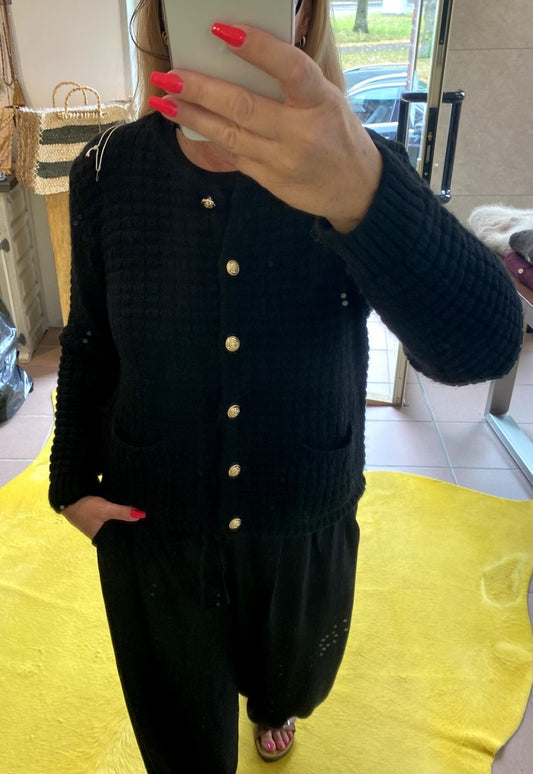 Die schwarze Cardigan-Strickjacke im Chanel-Stil mit ihren markanten Quadrate und edlen Goldknöpfen vereint zeitlose Eleganz mit modernem Komfort!