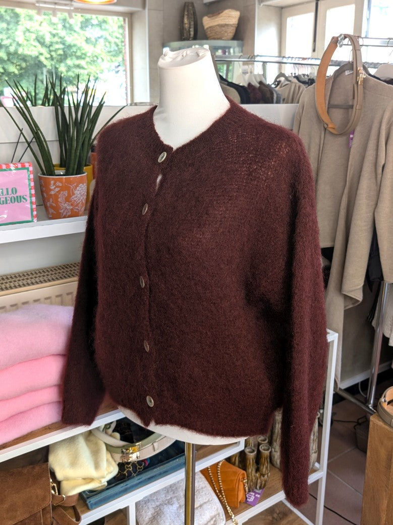 Fühle dich behaglich und stilvoll mit unserer Cardigan Strickjacke aus 80% Soft Kid Mohair Bordeaux Rot mit hellen Perlmuttknöpfen. Perfekt für alle Gelegenheiten