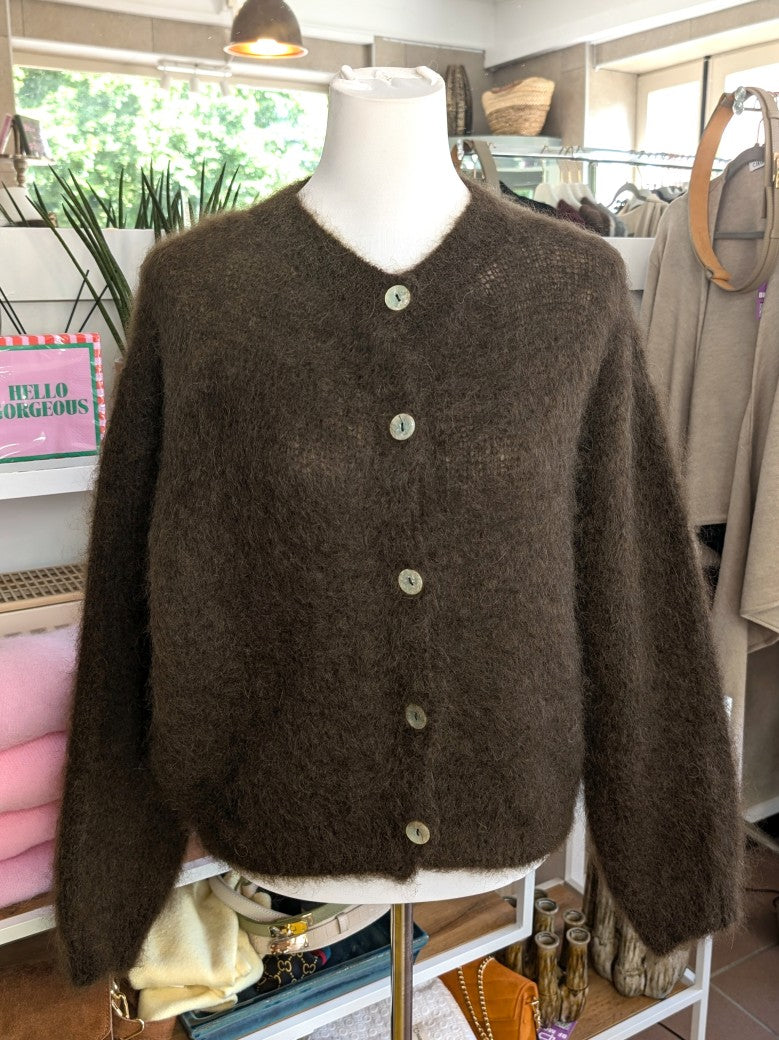 Fühle dich behaglich und stilvoll mit unserer Cardigan Strickjacke aus 80% Soft Kid Mohair Coffee Braun mit hellen Perlmuttknöpfen. Perfekt für alle Gelegenheiten