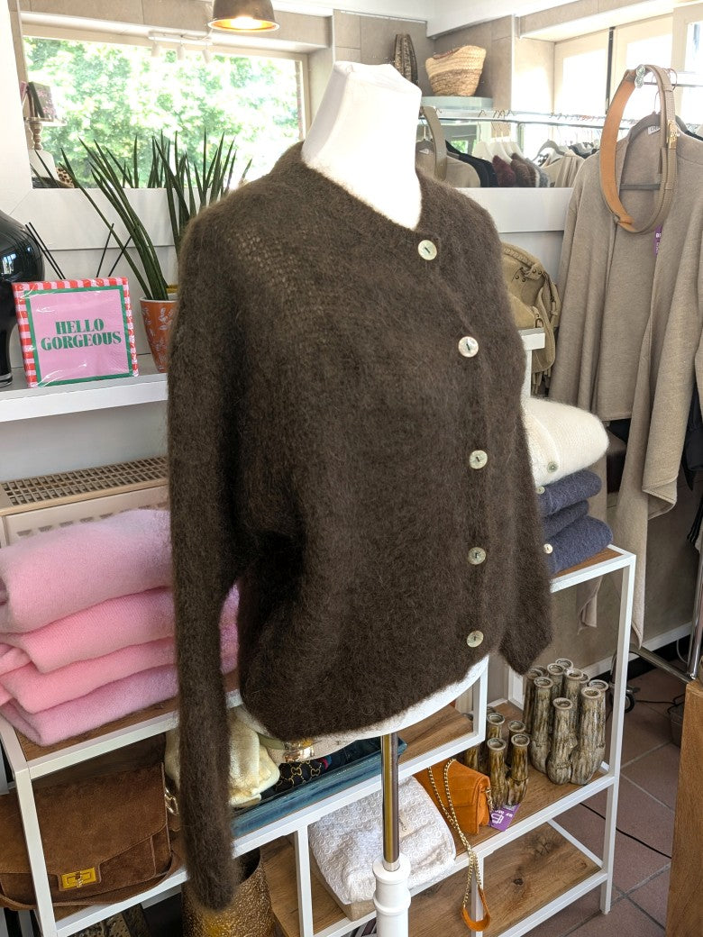 Fühle dich behaglich und stilvoll mit unserer Cardigan Strickjacke aus 80% Soft Kid Mohair Coffee Braun mit hellen Perlmuttknöpfen. Perfekt für alle Gelegenheiten