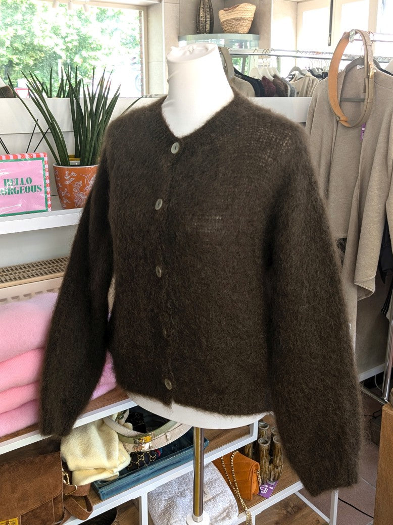 Fühle dich behaglich und stilvoll mit unserer Cardigan Strickjacke aus 80% Soft Kid Mohair Coffee Braun mit hellen Perlmuttknöpfen. Perfekt für alle Gelegenheiten