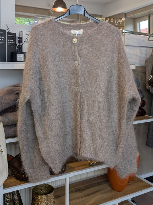 Fühle dich behaglich und stilvoll mit unserer Cardigan Strickjacke aus 80% Mohair in elegantem Taupe mit Perlmuttknöpfen. Perfekt für alle Gelegenheiten!