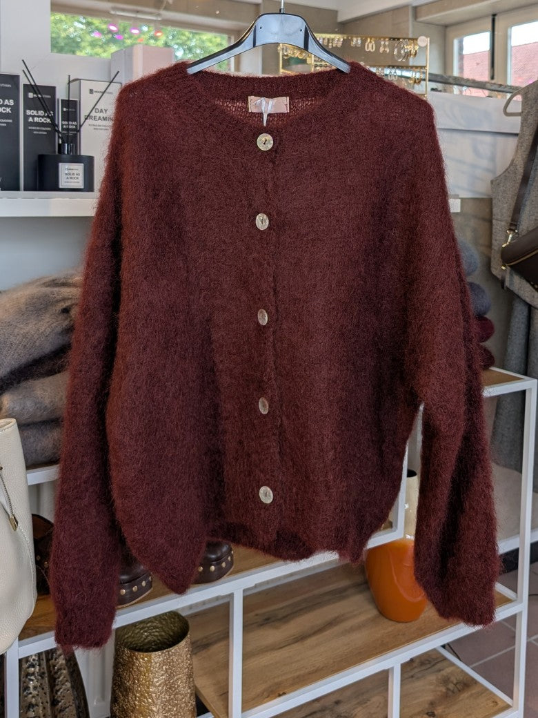 Fühle dich behaglich und stilvoll mit unserer Cardigan Strickjacke aus 80% Mohair in Weinrot und Braunstich mit Perlmuttknöpfen. Perfekt für alle Gelegenheiten!