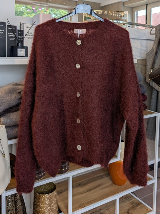 Fühle dich behaglich und stilvoll mit unserer Cardigan Strickjacke aus 80% Mohair in Weinrot und Braunstich mit Perlmuttknöpfen. Perfekt für alle Gelegenheiten!