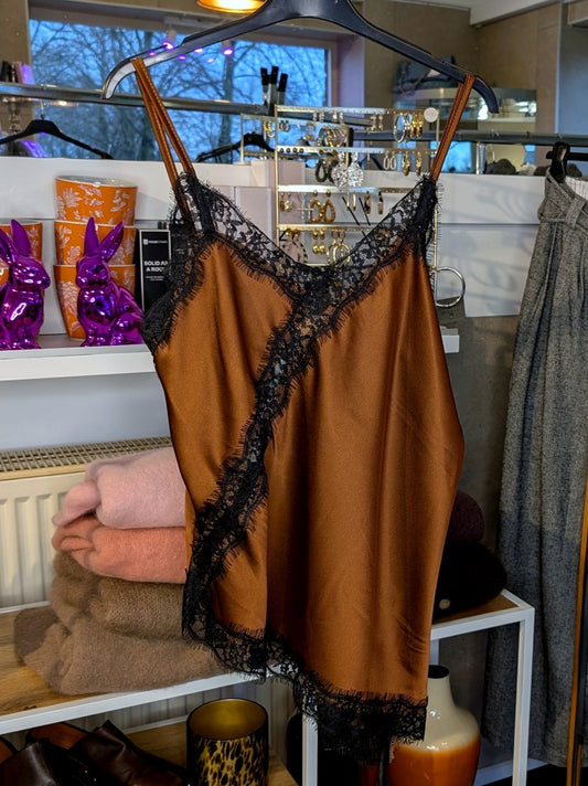 Elegantes seidiges asymmetrisches Satin-Top in warmem Kupferbraun, verfeinert durch zarte schwarze Spitzendetails. Qualität und Komfort, den Sie verdienen!