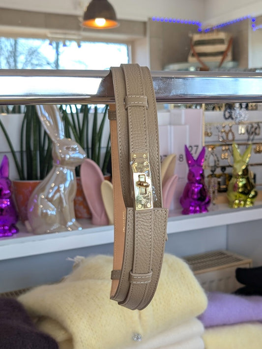 Eleganter verstellbarer Ledergürtel in warmem Schlamm-Taupe mit goldenem Verschluss. Die breite Ausführung betont die Taille – perfekt für verschiedenste Outfits!