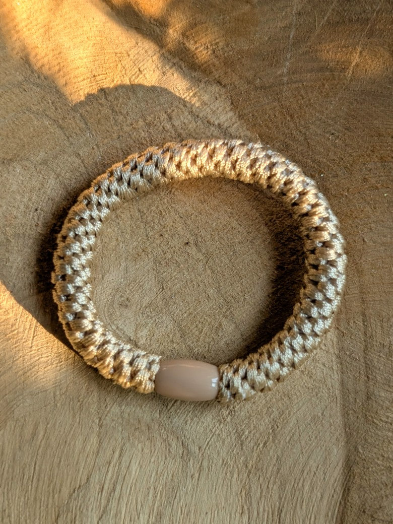 Das elastische Haargummi im trendigen Kknekki-Stil vereint Funktionalität mit modischem Chic - bequem als Armband oder schnell schonend die Haare zusammenbinden