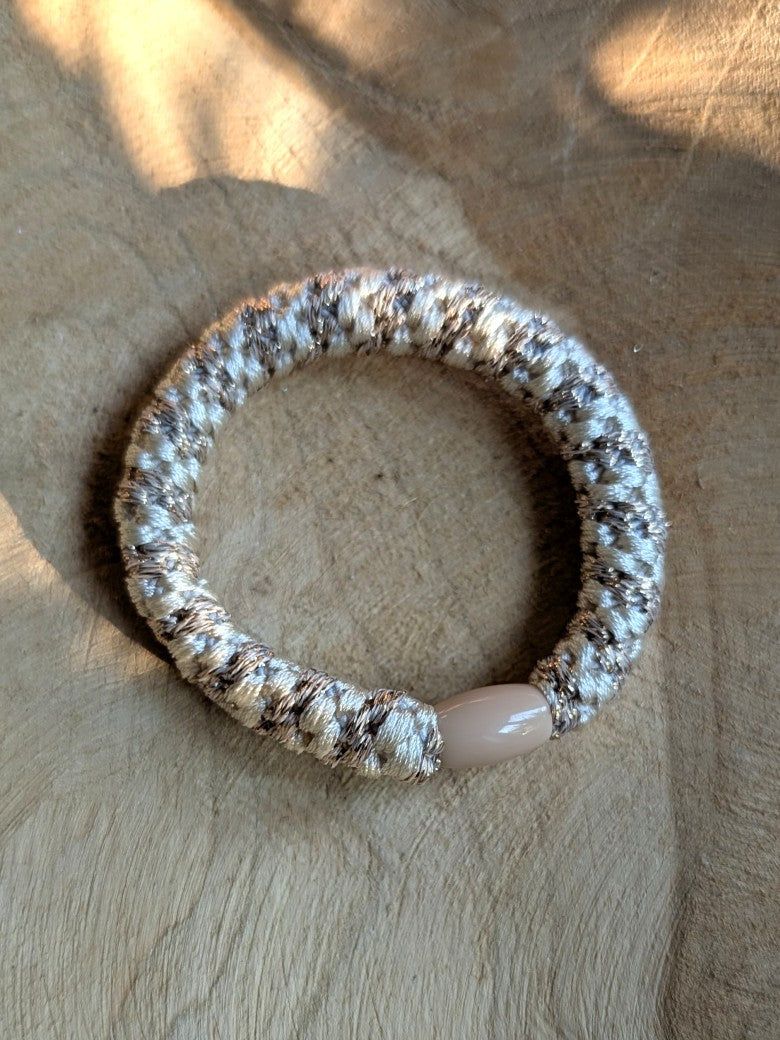 Das elastische Haargummi im trendigen Kknekki-Stil vereint Funktionalität mit modischem Chic - bequem als Armband oder schnell schonend die Haare zusammenbinden
