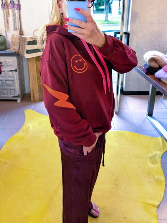 Der Hoodie von AZARA vereint lebendige Farben wie Burgunder/Brombeere mit Smiley und Blitzelementen in Neon Pink, Orange und Grün in einem einzigartigen Design!