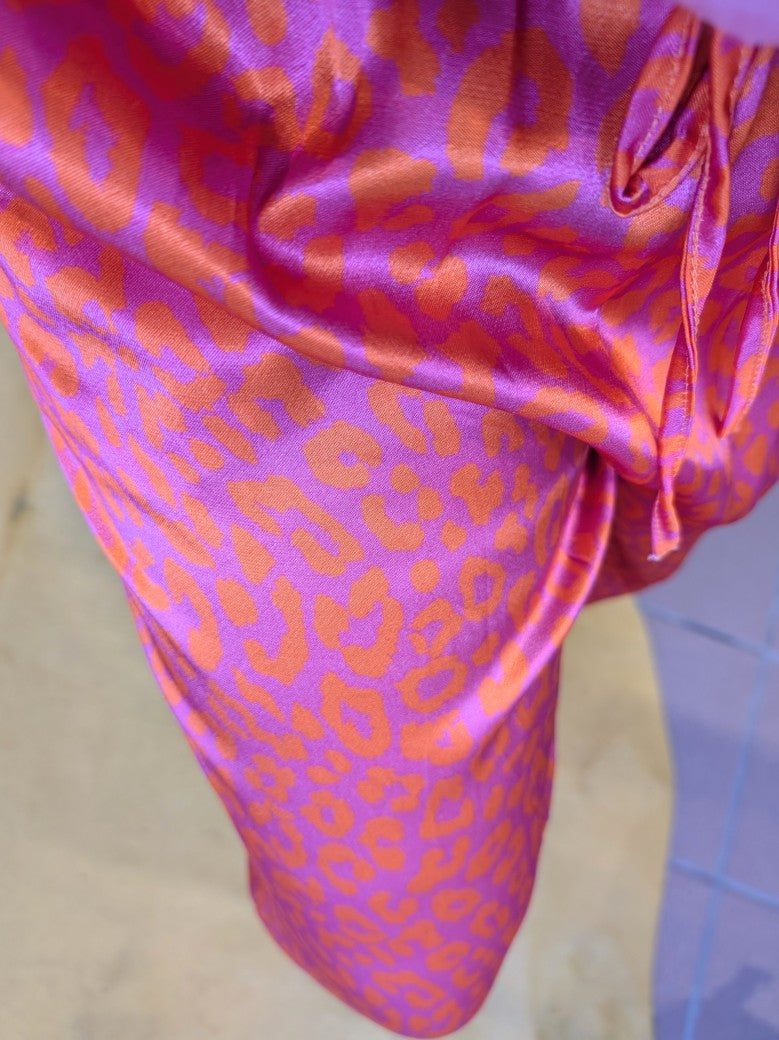 Entdecke deinen wilden und lebendigen Stil mit unserer Hose aus Satin Viskose mit verspieltem Leopardenmuster in Lila und Orange. Eyecatcher für jeden Anlass!