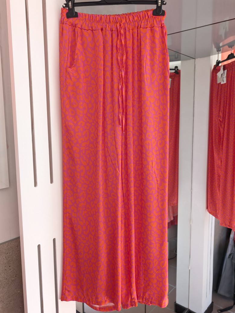 Entdecke deinen wilden und lebendigen Stil mit unserer Hose aus Satin Viskose mit verspieltem Leopardenmuster in Lila und Orange. Eyecatcher für jeden Anlass!