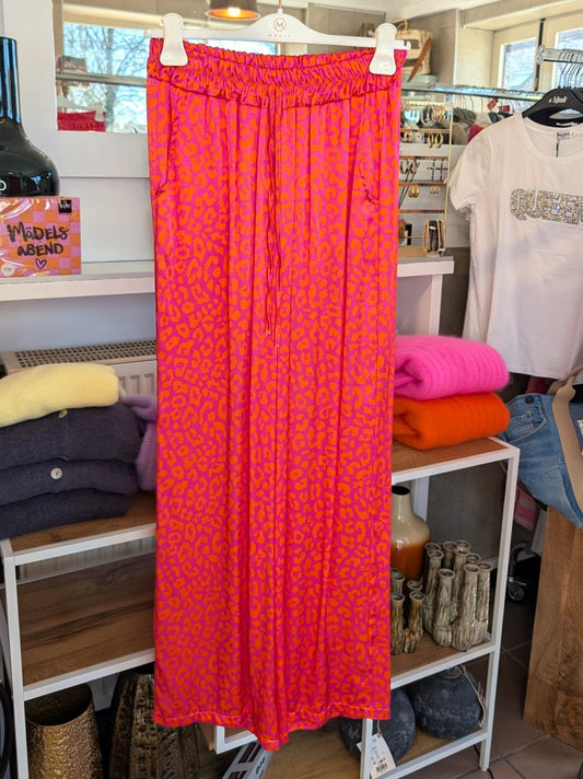 Entdecke deinen wilden und lebendigen Stil mit unserer Hose aus Satin Viskose mit verspieltem Leopardenmuster in Neon Pink Orange. Eyecatcher für jeden Anlass!